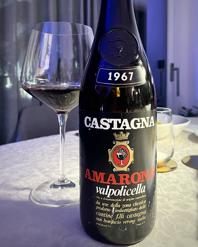 Bottiglia di Amarone 1967 Cantine Castagna con calice rosso in primo piano